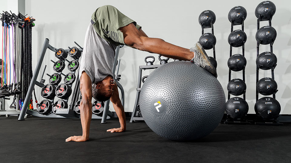 A girl performing a dumbbell press while using a stability ball 